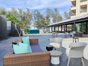ソンクラーにあるSolis Beach Hotel Rajamangalaのパティオ(ソファ、椅子、テーブル付)