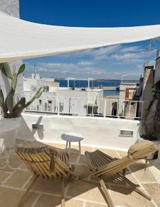 een patio met een tafel en een stoel op een gebouw bij Palmieri Luxury Rooms in Gallipoli