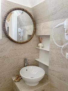 a bathroom with a white sink and a mirror at Palmieri Luxury Rooms in Gallipoli +66 photos