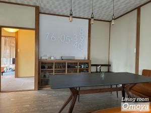 einen großen Bildschirm in einem Zimmer mit einem Tisch in der Unterkunft Vacation House YOKOMBO in Naoshima