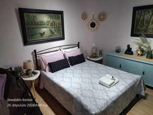 a bedroom with a bed with two towels on it at Zoe garden home in Spata