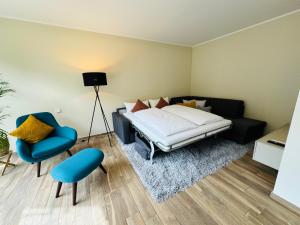 - une chambre avec un lit et une chaise bleue dans l'établissement Neu!!! Ferienwohnung Mosel 106,5, à Traben-Trarbach