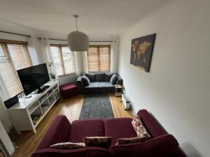 a living room with a couch and a tv at Beautiful 3-Bed Apartment in Hythe High Street in Hythe