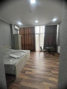 een slaapkamer met een bed en een tafel en stoelen bij Hotel Saba in Rustavi