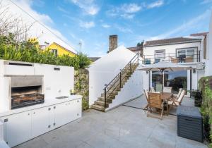 a kitchen with a patio with a table and chairs at Descanso das Palmeiras - HOST & CHILL in Furnas