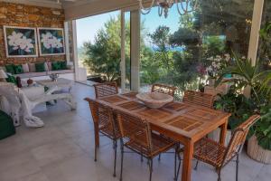 a dining room with a wooden table and chairs at Villa Zen Dans Le Bleu in Ermoupoli