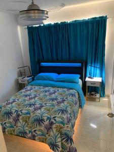 a bedroom with a blue bed with a blue curtain at Nice and Breezy Apartment in Santiago de los Caballeros