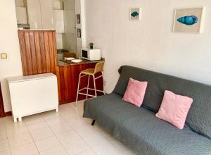 sala de estar con sofá verde y 2 almohadas rosas en Apartamento SomoMar, en Somo