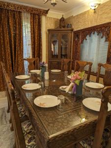 ein Esszimmer mit einem Tisch mit Platten und Blumen darauf in der Unterkunft Lamzy parimahal. in Srinagar