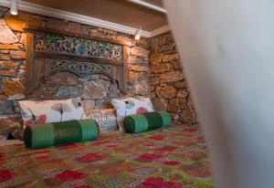 a room with a stone wall with two pillows and a table at Villa Zen Dans Le Bleu in Ermoupoli