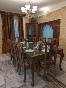 Lamzy parimahal. في سريناغار: غرفة طعام مع طاولة وكراسي خشبية