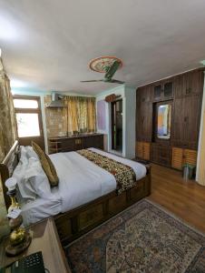 Schlafzimmer mit einem großen Bett und einer Decke in der Unterkunft Lamzy parimahal. in Srinagar