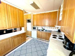 a large kitchen with wooden cabinets and white appliances at Simunakankaantie, Pyhäjoki in Pyhäjoki +7 photos