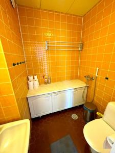 a bathroom with orange tiled walls and a shower at Simunakankaantie, Pyhäjoki in Pyhäjoki