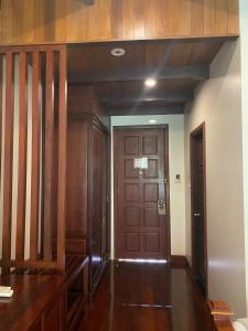 un pasillo con una puerta de madera en una casa en Athena Hotel en Pakse