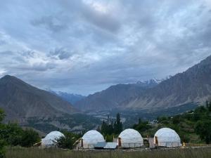 eine Gruppe von Kuppeln mit Bergen im Hintergrund in der Unterkunft Glamping Resort Hunza in Hunza