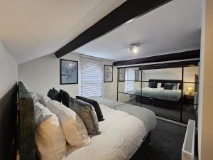 a bedroom with a large bed and a large mirror at Oxton Apartments - JCS Property 10 minutes from Central Liverpool in Upton