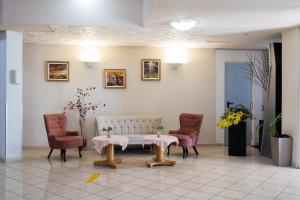 una sala de espera con mesa y 2 sillas en Iris Hotel, en Oradea