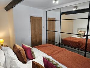a bedroom with two beds and a mirror at Oxton Apartments - JCS Property 10 minutes from Central Liverpool in Upton