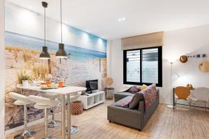 un soggiorno con una scena sulla spiaggia sul muro di Suite Jinetes a Málaga