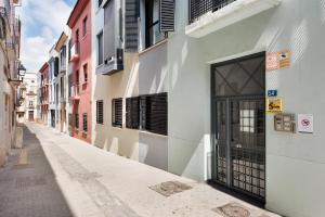 un vicolo vuoto con una porta su un edificio di Suite Jinetes a Málaga