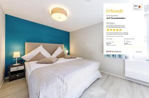 1 dormitorio con 1 cama grande y pared azul en Alte Seefahrtschule - Zwei Wasser, en Wustrow