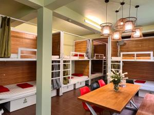 ハノイにあるHanoi EcoStay 1 hostelのテーブル、椅子、二段ベッドが備わる客室です。