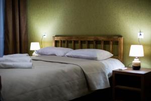 1 dormitorio con 2 camas con almohadas blancas y 2 lámparas en ციბენა • Tsibena en Ambrolauri