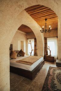 a large bedroom with a large bed in a stone wall at Hu of Cappadocia - Special Class in Uçhisar