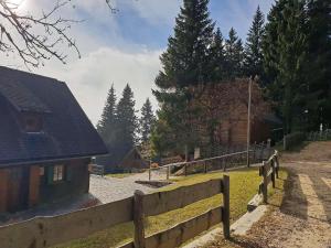 una valla de madera frente a una casa con patio en Almliesl STMA-666, en Sankt Margarethen im Lavanttal