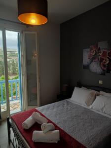 sypialnia z łóżkiem z dwoma ręcznikami w obiekcie Andros Guesthouses w mieście Andros