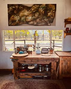 a kitchen with a table with a large bear painting on the wall at Highlands Farm Cottage in Van Reenen +32 photos