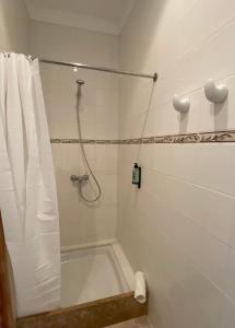 a bathroom with a bath tub and a shower at Hostal Palmaria in Cala Santanyi