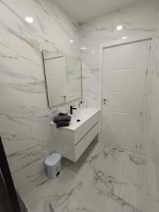 a white bathroom with a sink and a mirror at Nuevo apartamento cerca del mar in Denia