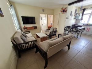 a living room with two couches and a tv at Le Mirage Exotique in Flic-en-Flac