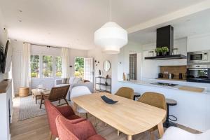 Una cocina y una sala de estar con una mesa y sillas de madera. en Vista Serena, en Sant Cugat del Vallès