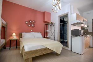 1 dormitorio con cama y pared roja en Gio Apartments, en Preveza