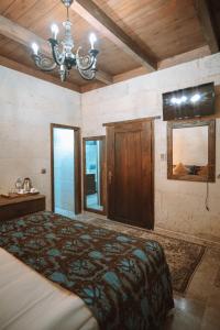 a bedroom with a large bed and a chandelier at Hu of Cappadocia - Special Class in Uçhisar