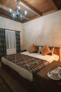 a bedroom with a large bed and a chandelier at Hu of Cappadocia - Special Class in Uchisar