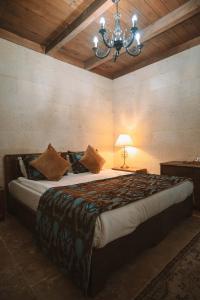 a bedroom with a large bed with a chandelier at Hu of Cappadocia - Special Class in Uchisar