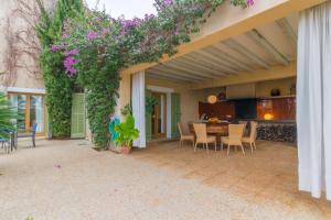 un patio con mesa, sillas y flores púrpuras en Buger - 3070 Mallorca, en Búger