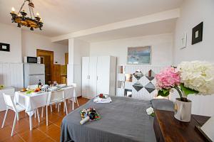 een keuken en eetkamer met een tafel en bloemen bij Tremosine Wonderful Lake View 1 in Tremosine Sul Garda