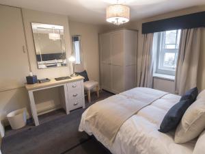 a bedroom with a bed and a desk and a mirror at New Crown Inn in Appleby