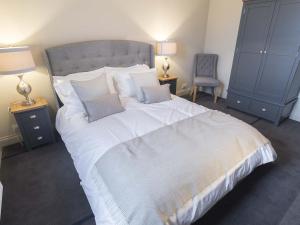 a bedroom with a large white bed with blue cabinets at New Crown Inn in Appleby