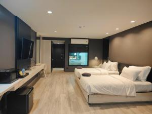 ソンクラーにあるSolis Beach Hotel Rajamangalaのベッドルーム1室(ベッド2台、薄型テレビ付)