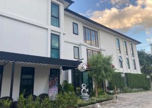 a white building with a statue in front of it at The Wing Boutique Hotel in Chiang Mai