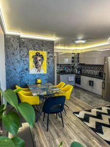 a kitchen with a dining table and yellow chairs at APARTMENT ROYAL ASENOVGRAD in Asenovgrad