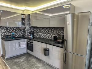 Il comprend une cuisine équipée d'un réfrigérateur en acier inoxydable. dans l'établissement APARTMENT ROYAL ASENOVGRAD, à Asenovgrad