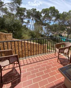 a patio with two chairs and a fence at Hostal Palmaria in Cala Santanyi