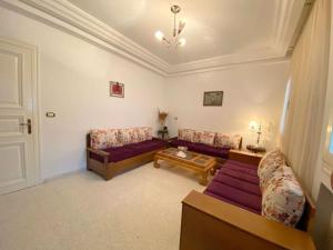 a living room with two couches and a table at The Epitome of Luxury: S+2 Apart & Parking Ennasr2 in Ariana